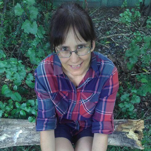 mels-sitting-on-log-in-garden-sm.jpg